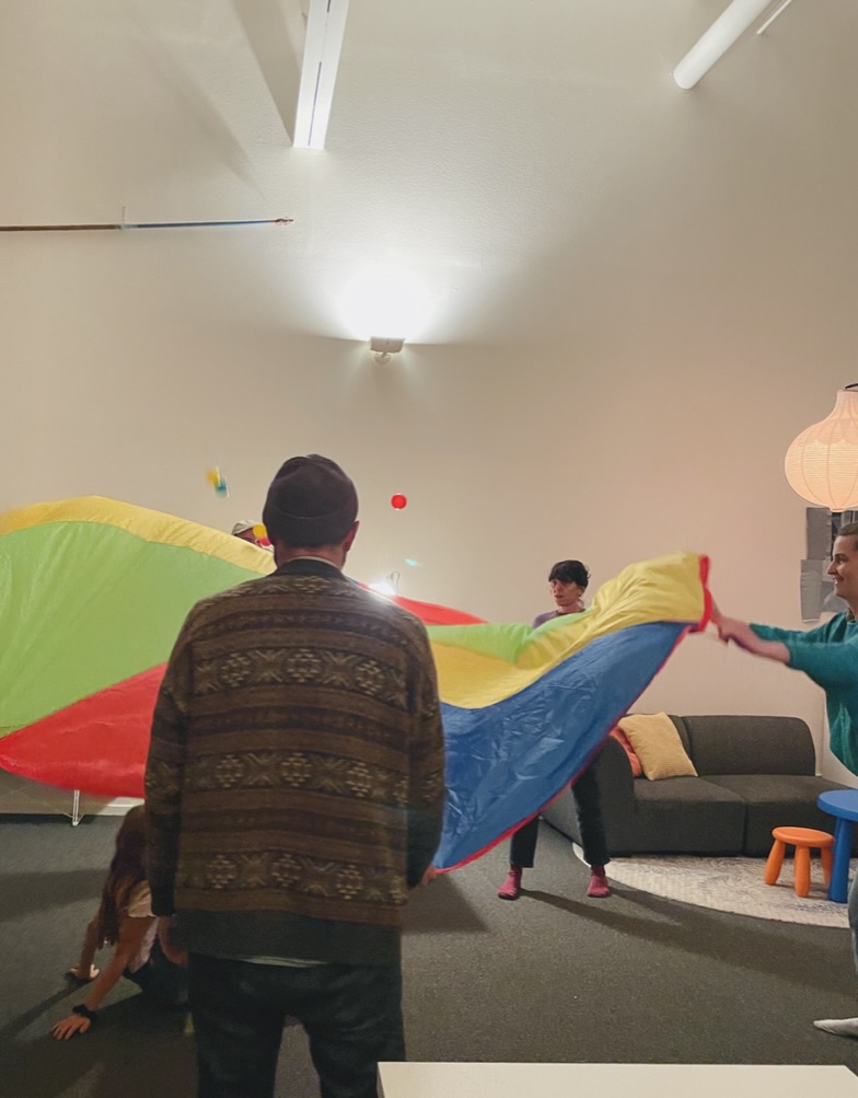 Playing with a colorful parachute in the loft